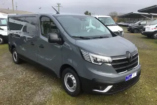 Renault Trafic Fourgon gris urbain en 3/4 avant droit, avec calandre noire et phares LED distinctifs.