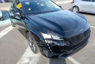Peugeot 308 noire vue en 3/4 avant droit, mettant en valeur sa calandre moderne et ses phares LED distinctifs.