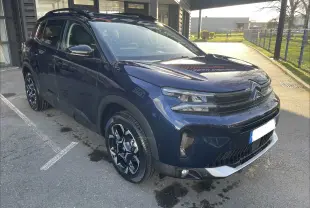 Citroën C5 Aircross hybride bleu Eclipse vue 3/4 avant droit, jantes alliage 18'' biton et barres de toit visibles.