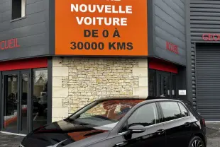 Volkswagen Golf noire vue en 3/4 avant droit, stationnée devant un bâtiment avec panneau orange Distinxion.