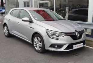 Renault Mégane gris titanium vue 3/4 avant droit, avec phares LED et jantes alliage visibles.