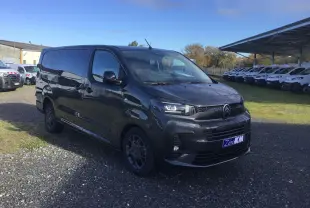 Citroën Jumpy Cabine Approfondie gris titane vu en 3/4 avant droit, avec calandre moderne et phares LED allumés.