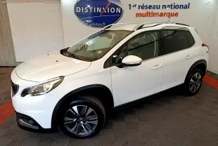Peugeot 2008 blanc vue 3/4 avant droit, avec jantes alliage et barres de toit chromées en intérieur showroom.