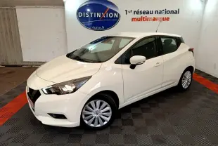 Nissan Micra blanche vue en 3/4 avant droit dans un showroom avec éclairage intérieur et logo Distinxion.