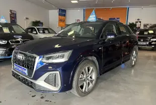 Audi Q2 30 TFSI S-Line bleu Navarre métal vue 3/4 avant droit en intérieur, calandre et jantes distinctives visibles