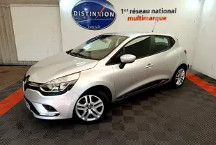 Renault Clio Business TCe 90 gris clair vue 3/4 avant droit dans un showroom avec sol noir et orange.