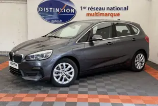 BMW Série 2 Active Tourer gris foncé vue 3/4 avant côté gauche dans un showroom multimarque.