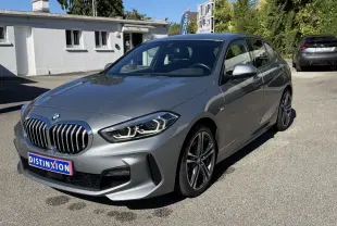 BMW Série 1 118i M Sport gris métallisé vue de profil côté gauche, avec jantes alliage et rétroviseurs alu.