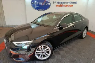 Audi A3 30 TFSI MHEV Business Line noire vue en 3/4 avant droit dans un showroom avec logo Distinxion en arrière-plan