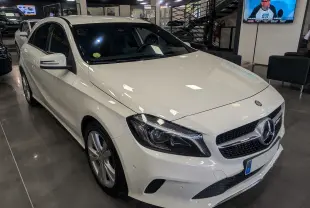 Mercedes Classe A 200d blanc vue 3/4 avant droit dans un showroom avec jantes alliage et calandre chromée.