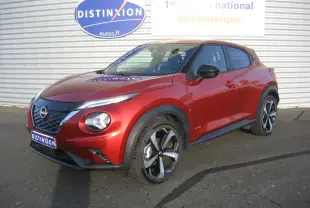 Nissan Juke 1.6 Hybrid 143 Tekna rouge en 3/4 avant droit avec jantes bi-ton et calandre noire brillante.
