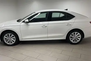 Profil côté gauche de la Skoda Octavia 2024 blanc candy, avec feux arrière allumés et jantes alliage visibles.