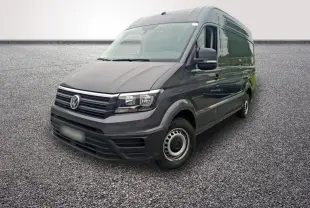 Volkswagen Crafter fourgon gris foncé vu en 3/4 avant droit sur sol gravillonné, avec jantes acier.