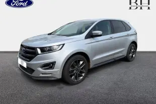 Vue 3/4 avant droite du Ford Edge gris Ingot avec jantes alliage foncé et attelage visible sous le pare-chocs arrière.