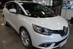 Renault Grand Scenic IV blanc Glacier en 3/4 avant droit, avec phares LED et calandre noire brillante.