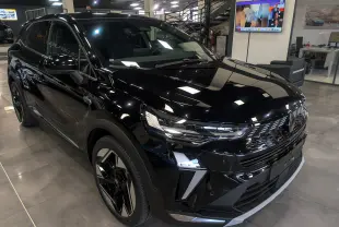 Vue 3/4 avant d’un Renault SYMBIOZ E-Tech full hybrid noir étoilé, avec calandre et phares LED distinctifs en showroom.