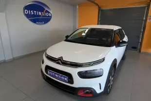 Citroën C4 Cactus blanc vue 3/4 avant droit en intérieur, avec détails rouges sur le pare-chocs et jantes biton.