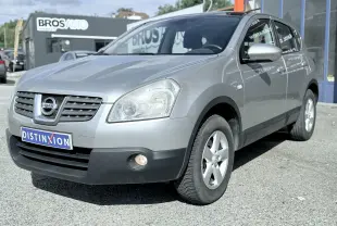 Nissan Qashqai gris vue 3/4 avant droit, avec phares et jantes alliage visibles sur fond neutre.
