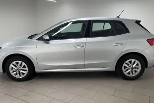 Profil côté gauche d'une Skoda Fabia 2025 gris argent, finition Selection avec jantes alliage et vitres teintées.