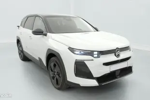 Citroën C5 Hybride blanc vue 3/4 avant droit avec toit noir et phares LED allumés dans un studio blanc.