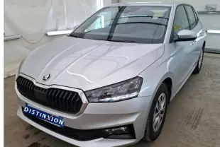 Vue 3/4 avant droite d'une Skoda Fabia Ambition gris clair 2023 avec calandre noire et phares LED allumés.