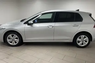 Volkswagen Golf 2022 en peinture métallisée reflet d'argent vue de profil côté gauche dans un intérieur neutre.