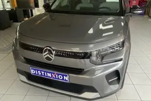 Citroën C3 turbo 100cv gris Mercury vue 3/4 avant en intérieur, avec calandre noire et phares LED distinctifs.