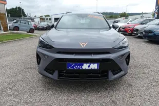 Vue frontale d'une CUPRA Formentor gris Graphène avec logo cuivré et calandre noire sur un parking.