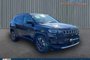 Jeep Compass noir en 3/4 avant droit, avec barres de toit et jantes 18 pouces visibles sur sol goudronné.