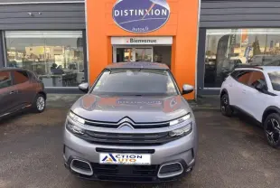 Vue de face d'un Citroën C5 Aircross gris Platinium avec calandre distinctive et phares LED allumés.