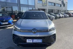 Vue de face du Volkswagen Tiguan 1.5 eHybrid gris métal, version R-line, avec calandre noire et logo central visible.