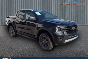 Ford Ranger Wildtrak noir en 3/4 avant droit, avec barres de toit, marchepieds et jantes alliage 18 pouces.