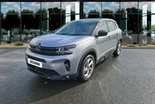 Citroën C5 Aircross gris clair en 3/4 avant droit, avec calandre noire et feux LED distinctifs sous la pluie.