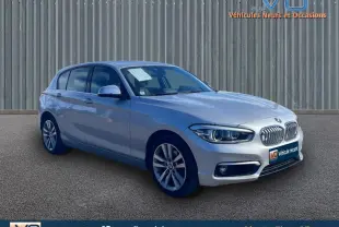 BMW Série 1 F20 LCI 118d gris clair vue 3/4 avant avec jantes alliage 17 pouces sur fond neutre.