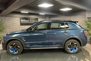 Profil côté gauche du SUV Lynk & Co 01 bleu métallisé avec jantes originales bicolores en showroom.