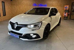 Renault Mégane IV RS 280 EDC6 blanche vue 3/4 avant droit en intérieur avec jantes noires et éclairage LED allumé.