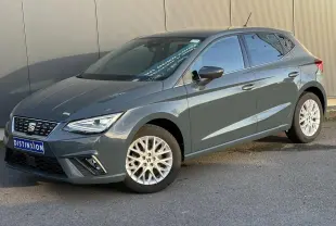 Vue 3/4 avant droite d'une SEAT Ibiza gris métallisé avec jantes alliage et calandre noire au logo centré.
