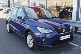 SEAT Arona bleu électrique vu en 3/4 avant droit, avec calandre noire et jantes alliage argentées.