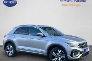 Volkswagen T-Roc 2025 gris métallisé en vue 3/4 avant droit avec jantes alliage et barres de toit.