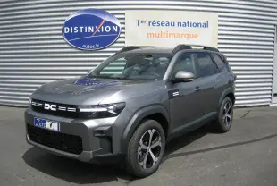 Dacia Bigster gris schiste en 3/4 avant droit, SUV hybride avec calandre noire et jantes modernes.