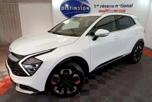 KIA SPORTAGE blanc en 3/4 avant droit, mettant en valeur ses phares LED en forme de flèche et ses jantes noires distinctives.