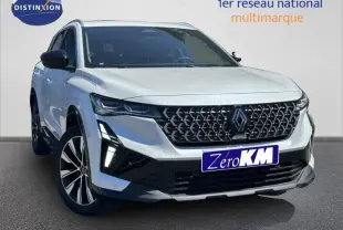 Renault Austral blanc nacré en 3/4 avant droit, avec calandre noire à motif géométrique et feux LED distinctifs.