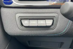 Gros plan sur les commandes E-Save et réglage des phares sur tableau de bord en tissu gris avec surpiqûres bleues.