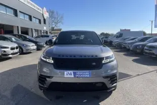 Vue frontale d'un Range Rover Velar gris métal 2020 avec phares LED allumés sur un parking extérieur.