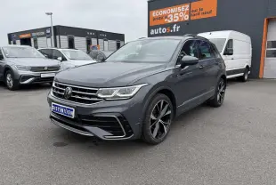 Volkswagen Tiguan gris dauphin en 3/4 avant droit avec jantes alliage noires et calandre chromée visible.