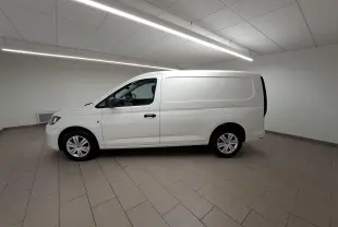 Vue de profil côté gauche du Volkswagen Caddy Cargo Maxi blanc candy 2026 dans un intérieur neutre.