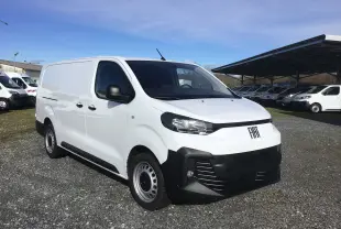 Vue 3/4 avant droite du FIAT Scudo Fourgon blanc 2024 avec pare-chocs noir et jantes acier, stationné sur un sol gravillonné.