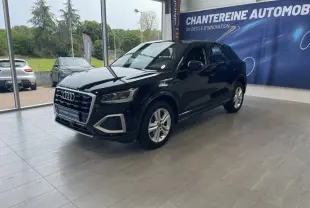 Audi Q2 noir vue 3/4 avant droit en showroom, mettant en valeur sa calandre distinctive et ses jantes argentées.