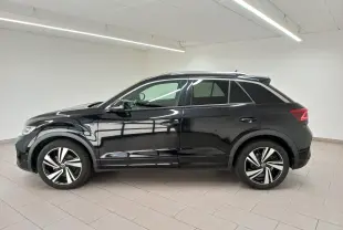 Profil droit du Volkswagen T-Roc 1.5 TSI 150 DSG7 R-Line noir intense nacré, avec jantes alliage distinctives en intérieur neutre.