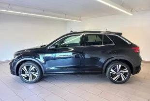 Vue de profil côté gauche d’un Volkswagen T-Roc 2025 noir intense avec jantes alliage et toit ouvrant panoramique.